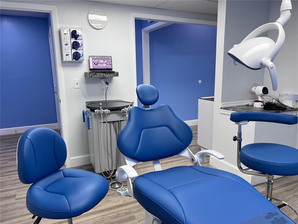 A dental exam room features blue chairs, a dental light, and medical equipment — 105 BELLAGIO CIRCLE, SANFORD, FL