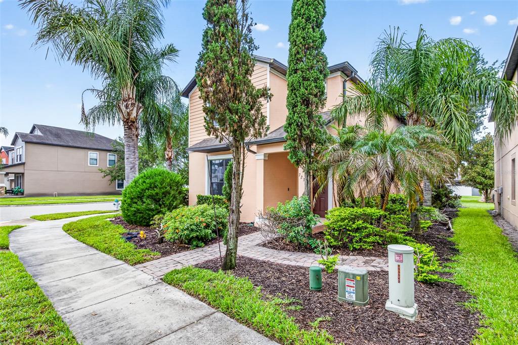 A two-story house with a peach-colored exterior, palm trees, and a paved walkway — 7236 PENKRIDGE LANE, WINDERMERE, FL