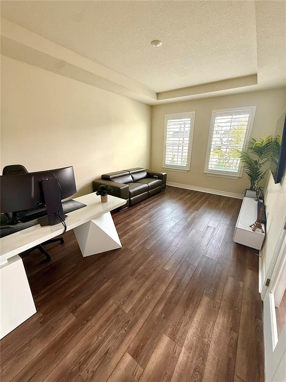 A home office features wood-look flooring, a white desk, a dark leather sofa, and two windows — 8441 PARK CLIFF WAY, ORLANDO, FL