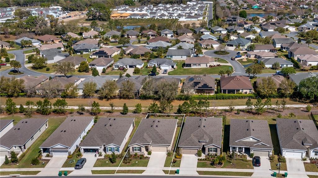 An aerial view shows a suburban neighborhood with single-family homes and manicured lawns — 8033 PENROSE PLACE, WILDWOOD, FL