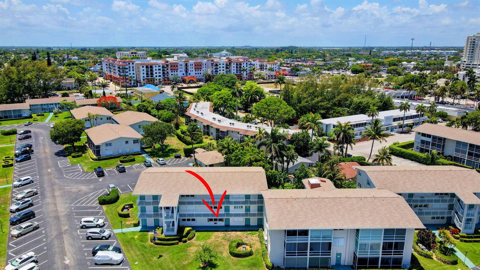 An aerial view shows a multi-story apartment building with a red arrow pointing toward a balcony — 210 Horizons E # 103, Boynton Beach FL 33435, BOYNTON BEACH, FL