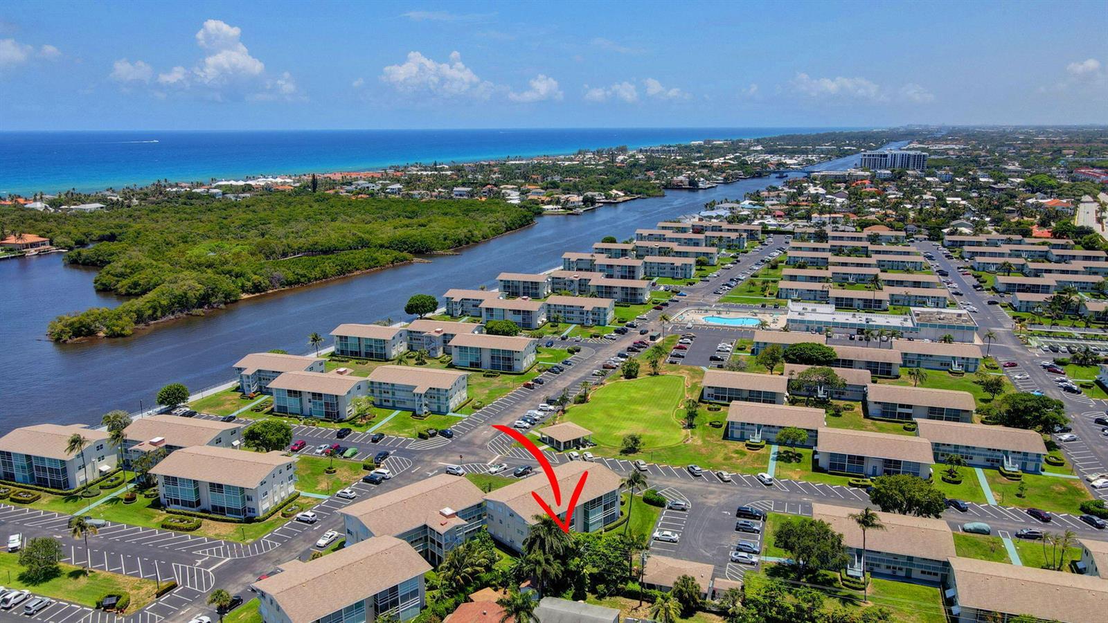 An aerial view shows a multi-story residential building complex with parking lots and a waterway — 210 Horizons E # 103, Boynton Beach FL 33435, BOYNTON BEACH, FL