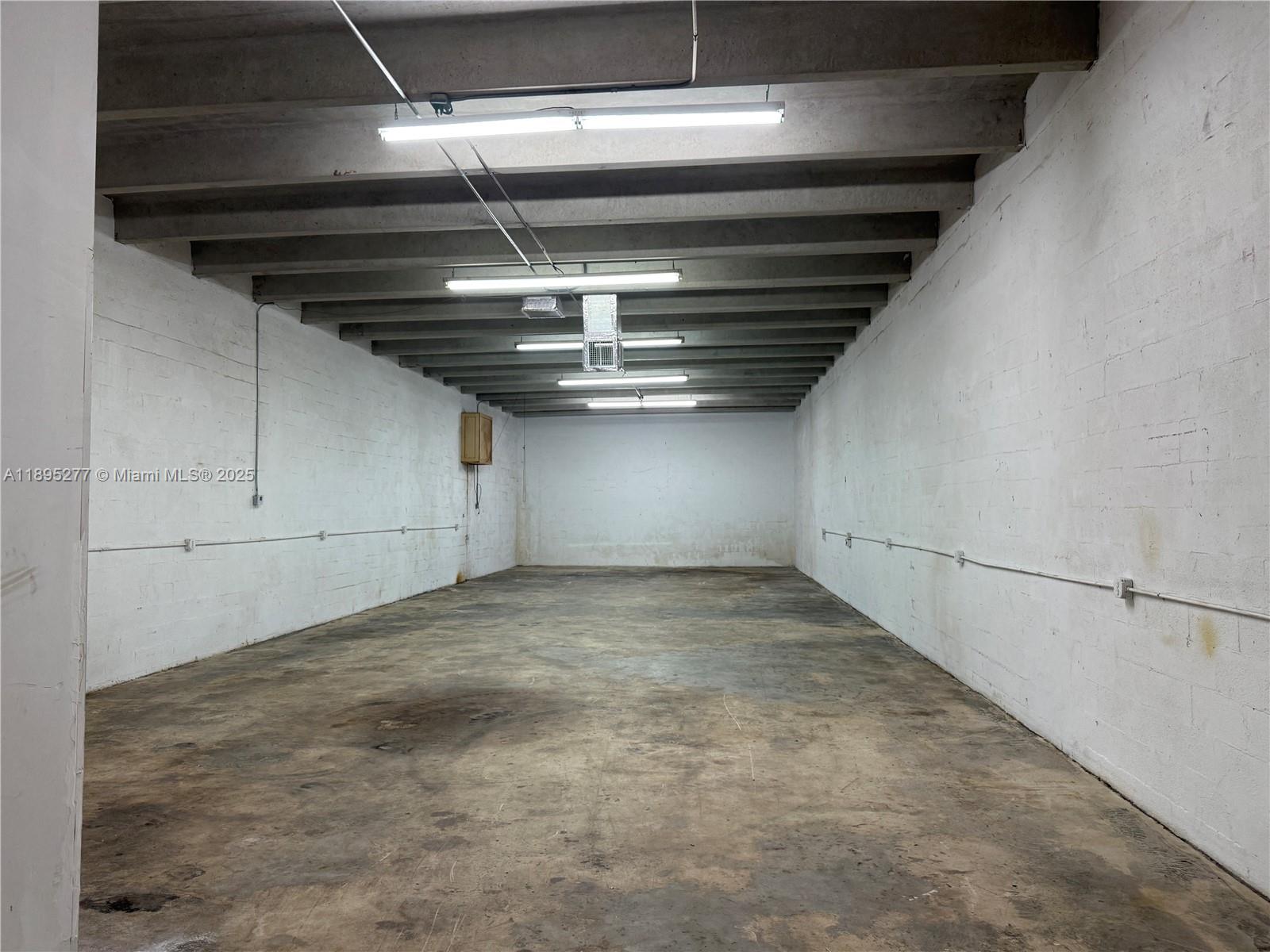 An empty industrial storage room features white concrete block walls, exposed ceiling beams, and concrete floors — 1870 NW 21 TERRACE, Miami FL 33142, MIAMI, FL