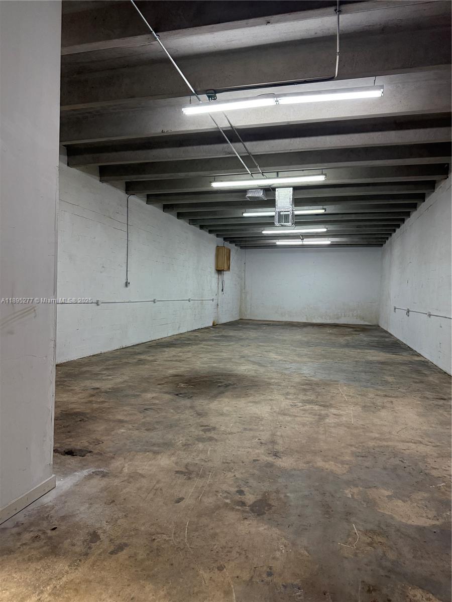 An empty industrial warehouse space features white concrete walls, exposed ceiling beams, and a stained concrete floor — 1870 NW 21 TERRACE, Miami FL 33142, MIAMI, FL