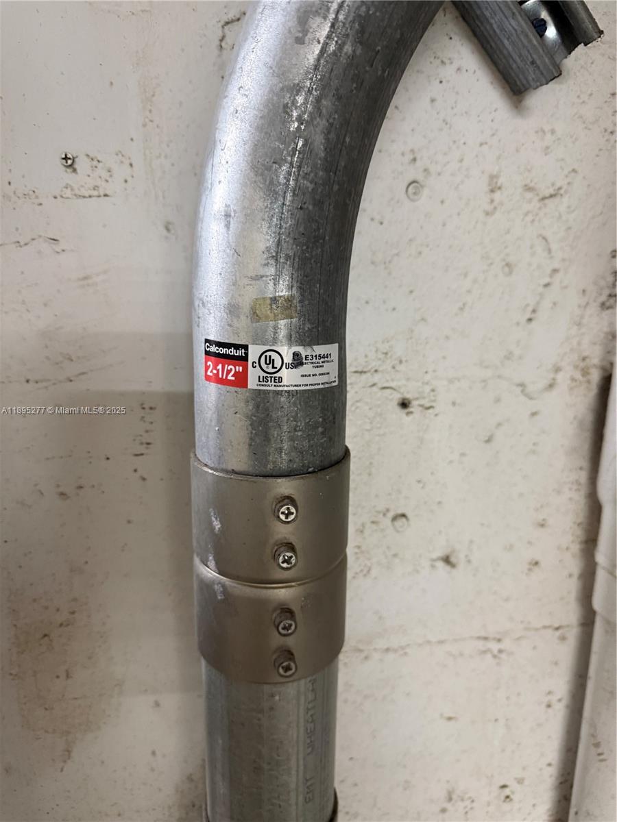 A close-up view shows a 2-1/2 inch electrical conduit pipe connected by a metal coupling — 1870 NW 21 TERRACE, Miami FL 33142, MIAMI, FL