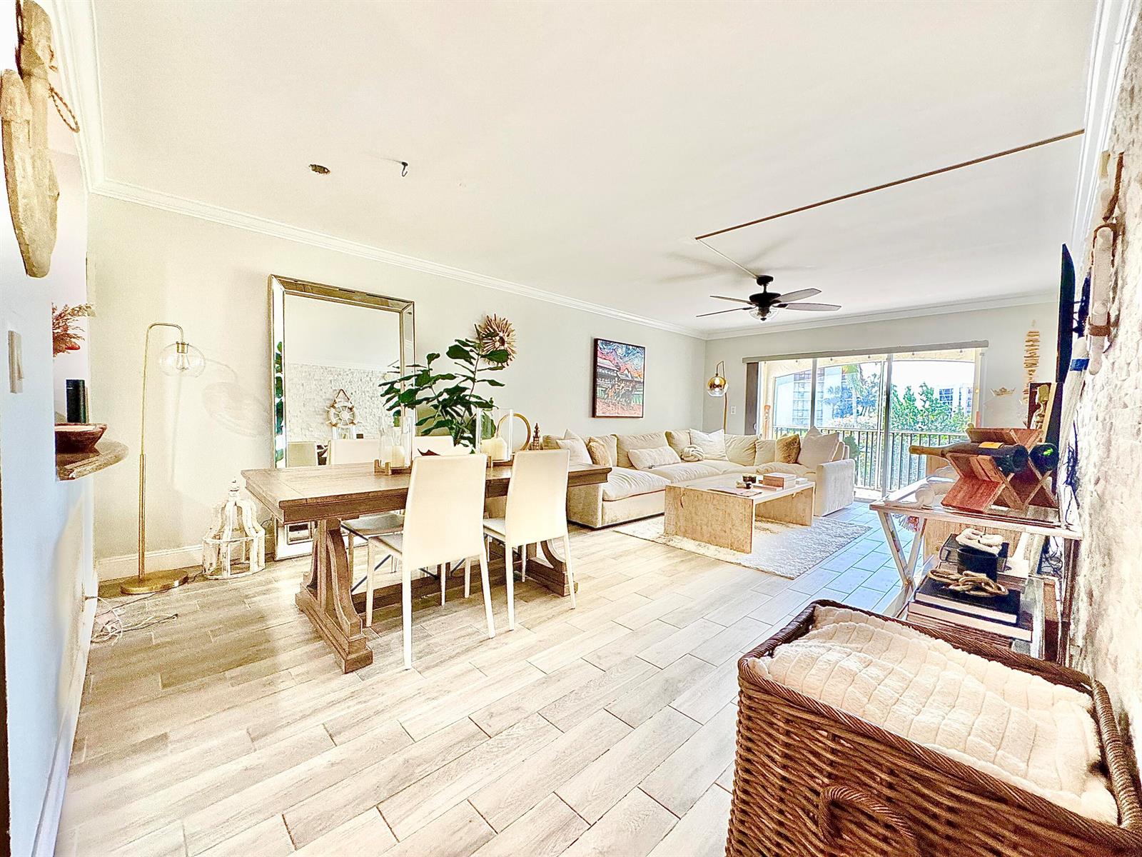 A bright living and dining area features light wood-look tile flooring and a sectional sofa — 2871 N Ocean Boulevard # R248, Boca Raton FL 33431, BOCA RATON, FL