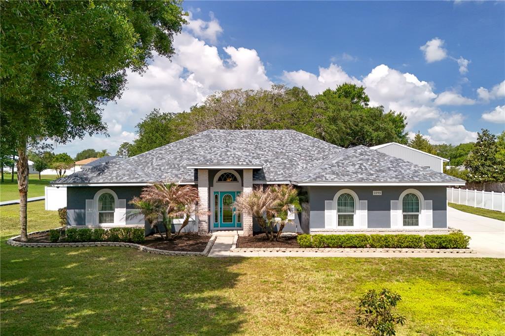 A single-story house with a gray exterior, white shutters, and a teal front door — 1095 W LAKE HAMILTON DRIVE, WINTER HAVEN, FL