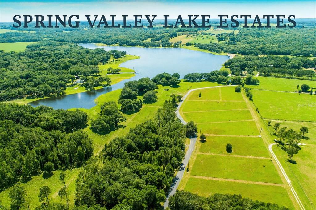 An aerial view shows a lake surrounded by green fields and wooded areas — 34710 CLAYTON ROAD UNIT 9, DADE CITY, FL
