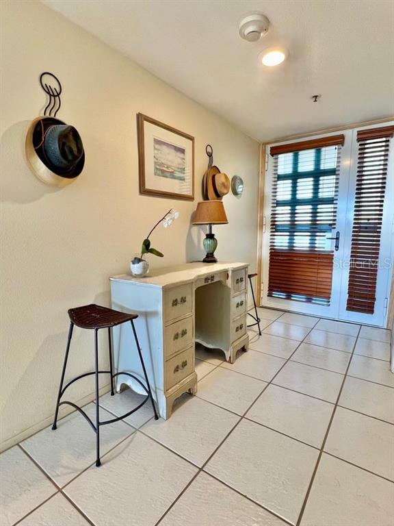 A desk with a lamp and stool sits in a tiled entryway near a door — 1065 GULF OF MEXICO DRIVE UNIT 302, LONGBOAT KEY, FL