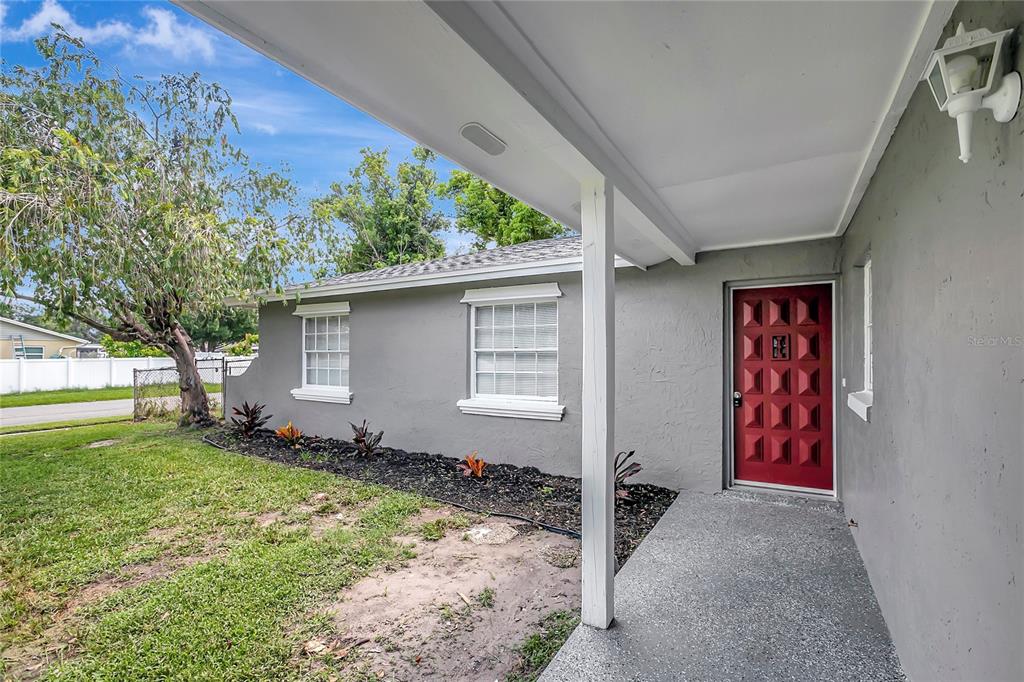 A gray house exterior features a red front door, a covered porch, and two windows — 917 WINCHESTER COURT, BRANDON, FL