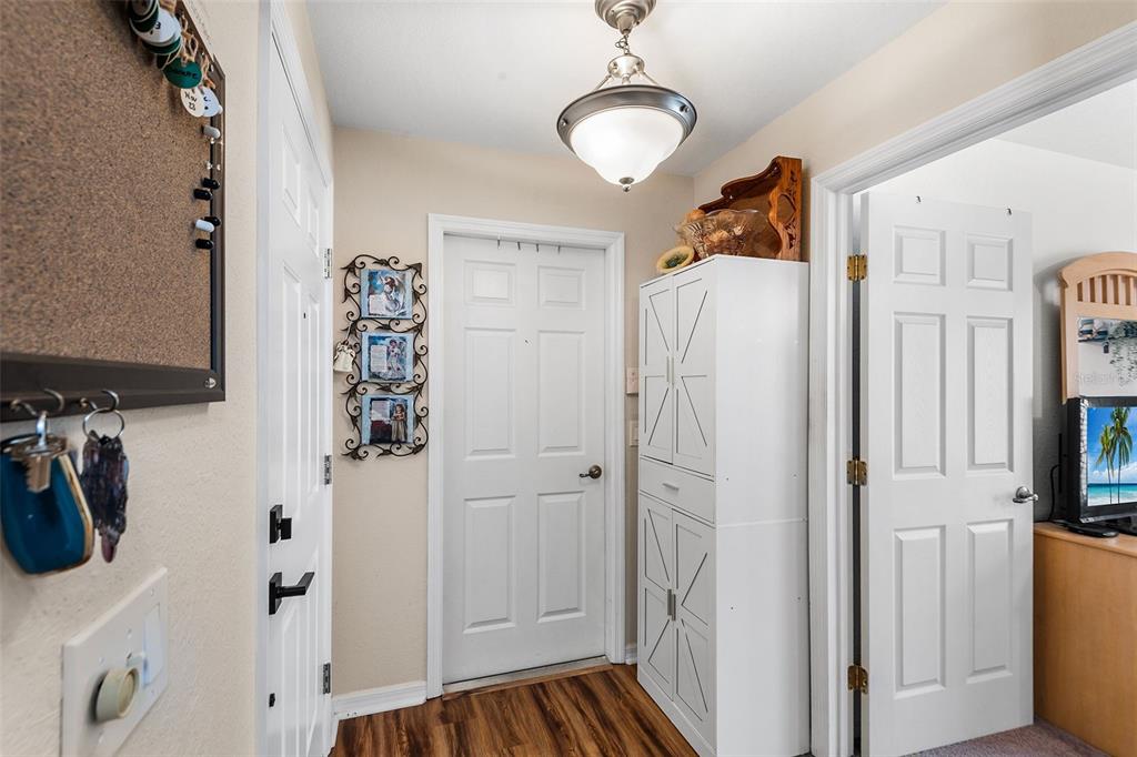 A hallway features a white door, a tall storage cabinet, and a ceiling light fixture — 4436 TURNBERRY LANE, LAKE WALES, FL