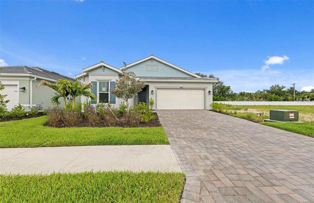 A single-story house with a paved driveway, a two-car garage, and a landscaped front yard — 1840 SILVER SHORES BOULEVARD, ENGLEWOOD, FL
