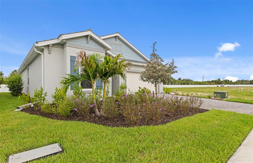 A single-story house with a light-colored exterior, blue accents, and a landscaped front yard — 1840 SILVER SHORES BOULEVARD, ENGLEWOOD, FL