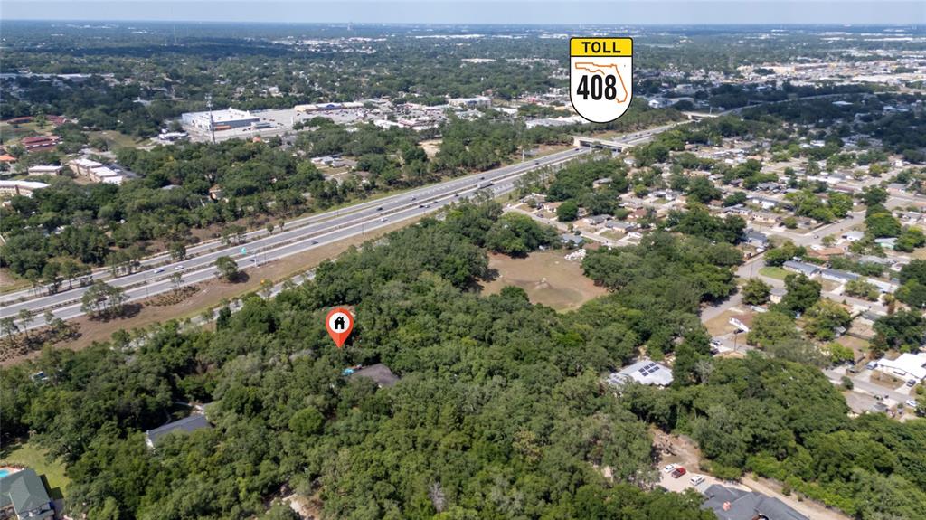 This aerial view shows a wooded residential lot located near the Toll 408 highway — 6781 W LIVINGSTON STREET, ORLANDO, FL
