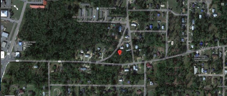 This is a satellite map view showing a red location pin on a wooded lot — 2916 MILTON AVENUE, MARIANNA, FL