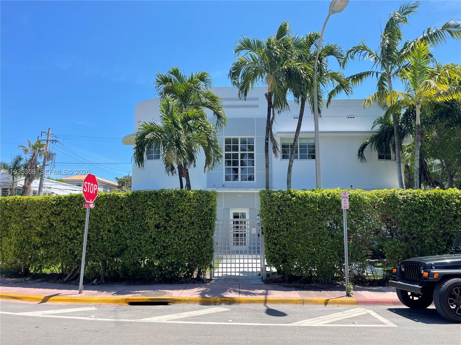 A two-story white Art Deco building sits behind a tall green hedge with palm trees — 600 15th St # 10, Miami Beach FL 33139, MIAMI BEACH, FL