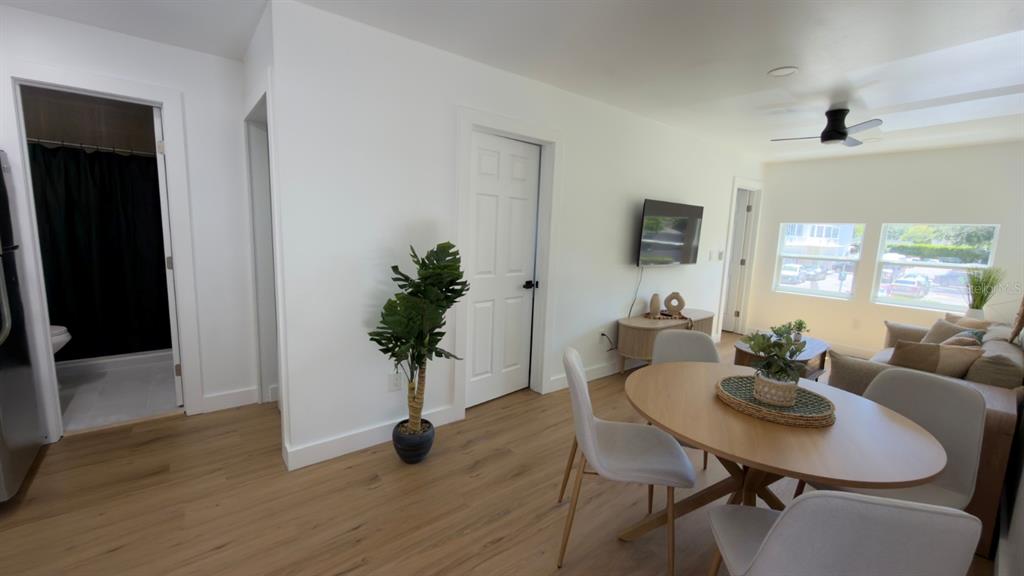 A living and dining area features light wood flooring, white walls, and a ceiling fan — 1922 HILLCREST STREET, ORLANDO, FL