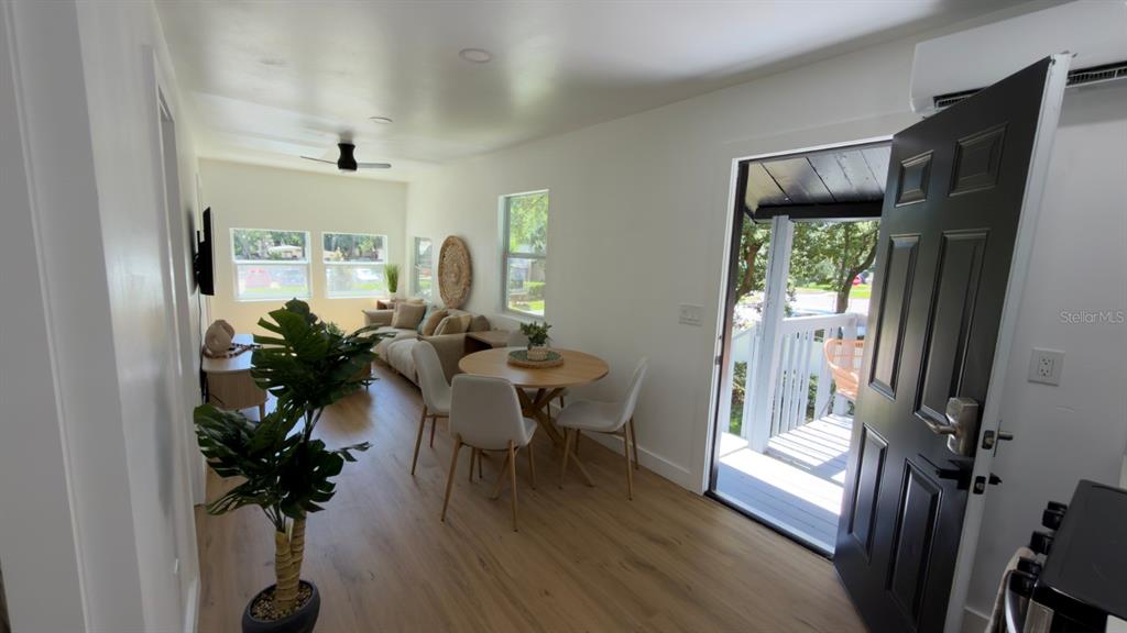 A bright living and dining area features light wood flooring, white walls, and a deck — 1922 HILLCREST STREET, ORLANDO, FL