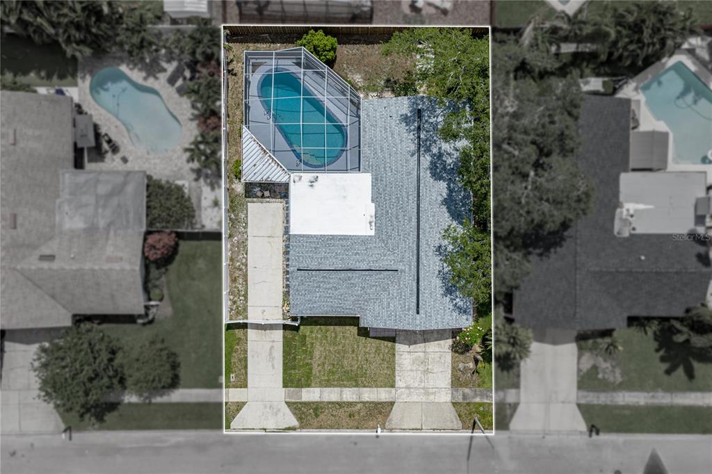 The exterior of a white house features a dark gray front door and garage door — 9305 120TH LANE, SEMINOLE, FL