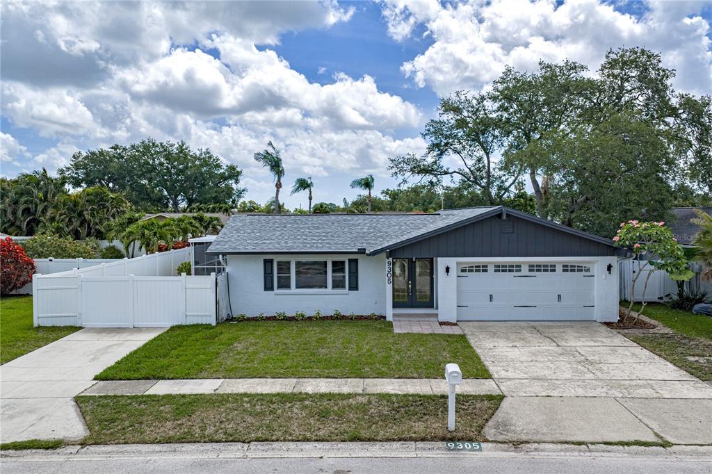 A kitchen with white cabinets and a dining area featuring dark blue cabinets and shelving — 9305 120TH LANE, SEMINOLE, FL