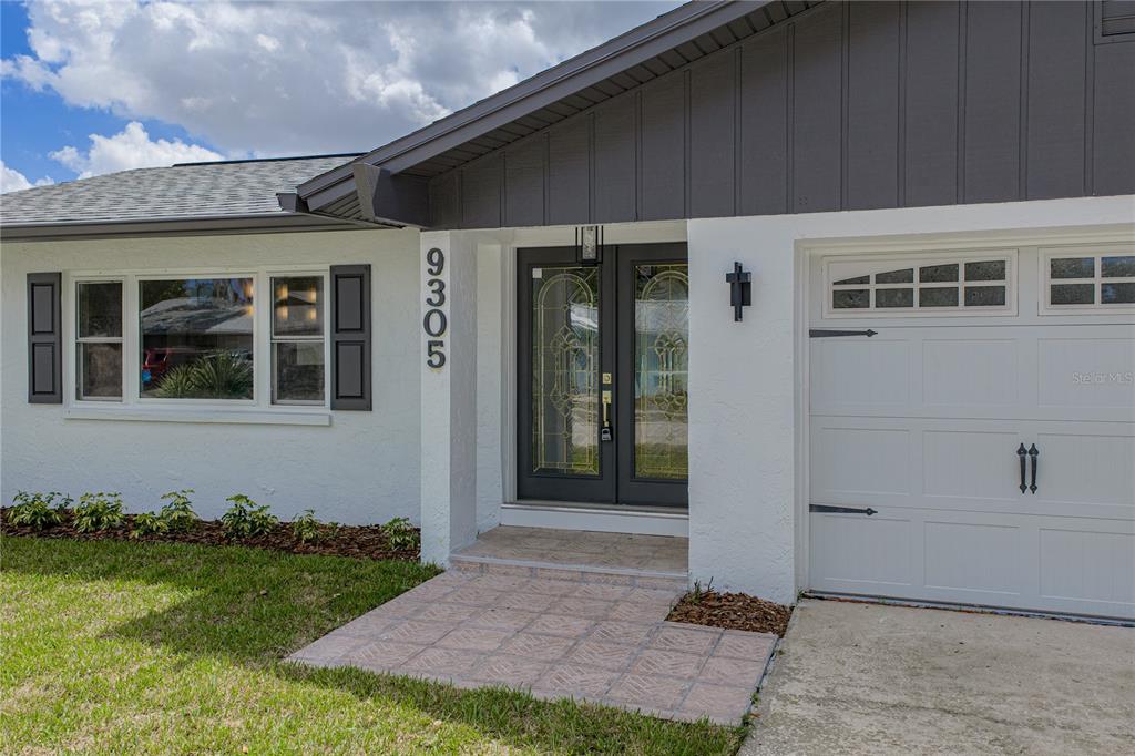 A modern kitchen features white cabinets, stainless steel appliances, gray tile backsplash, and quartz countertops — 9305 120TH LANE, SEMINOLE, FL