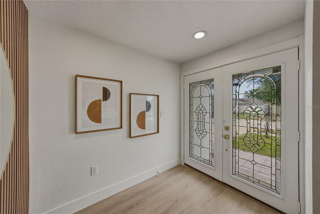 A modern kitchen features white cabinets, stainless steel appliances, and a quartz-topped island — 9305 120TH LANE, SEMINOLE, FL