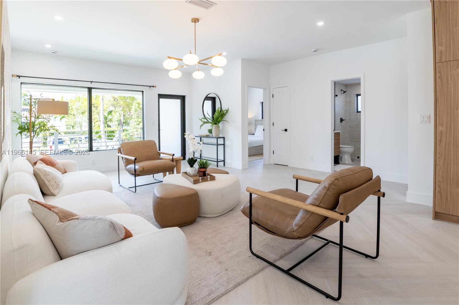 A bright living room features white sofas, leather armchairs, a round ottoman, and light flooring — 1420 SW 17th St # 0, Miami FL 33145, MIAMI, FL