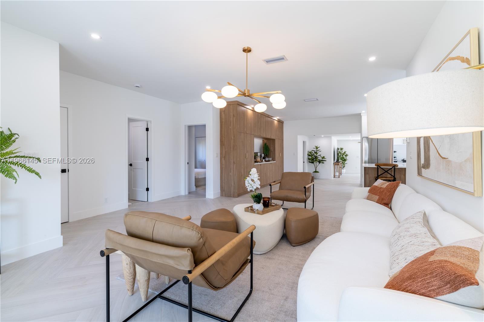 A modern living room features a white sofa, leather armchairs, and a wood-paneled accent wall — 1420 SW 17th St # 0, Miami FL 33145, MIAMI, FL