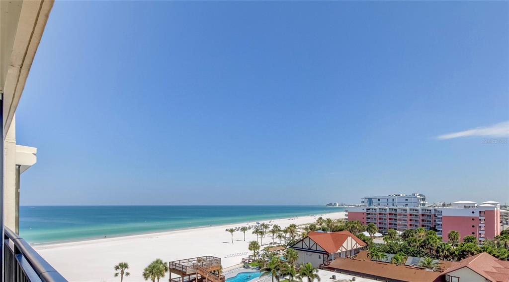 A high-angle view of a white sand beach and ocean from a balcony — 3820 GULF BOULEVARD UNIT 608, ST PETE BEACH, FL