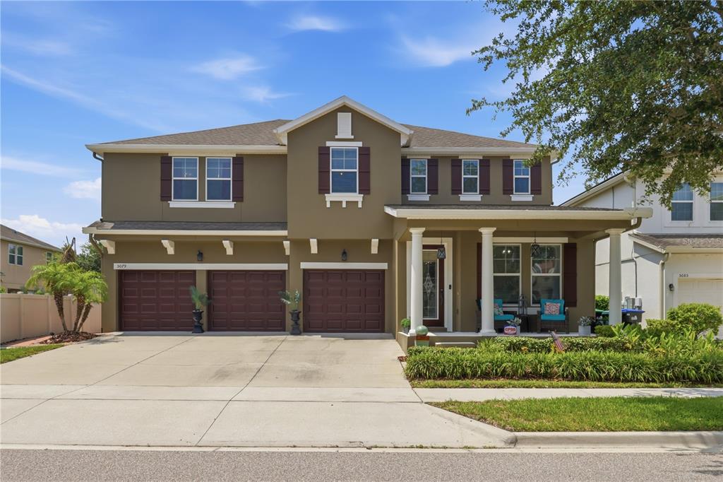 A two-story house with a three-car garage, brown exterior, and a covered front porch — 5079 PALMETTO PARK DRIVE, WINTER GARDEN, FL