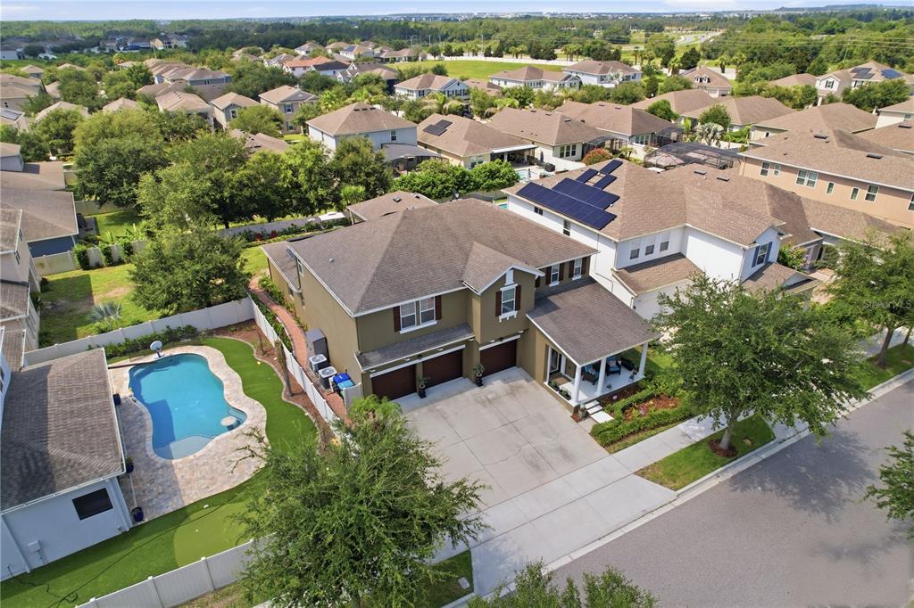 An aerial view of a two-story suburban house with a pool and solar panels — 5079 PALMETTO PARK DRIVE, WINTER GARDEN, FL