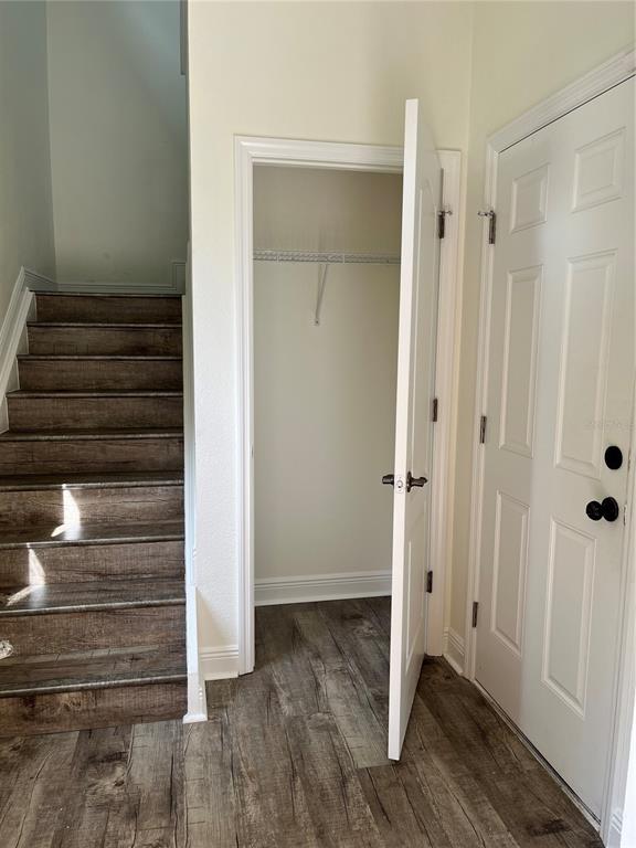 A staircase with wood-look steps sits beside an open closet and a white door — 200 RIVERVIEW BEND UNIT 921, PALM COAST, FL