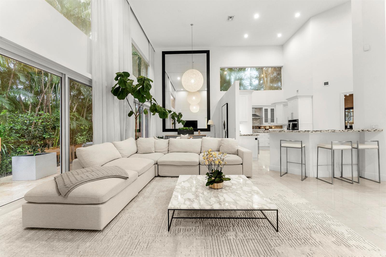 A bright, open-concept living room features a large sectional sofa, marble coffee table, and windows — 3156 NW 61st Street, Boca Raton FL 33496, BOCA RATON, FL