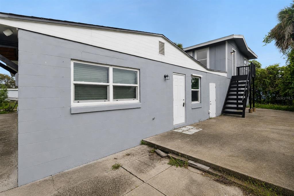 A gray, single-story building with a white upper gable and an exterior staircase — 1125 GAINEY DRIVE, MELBOURNE, FL