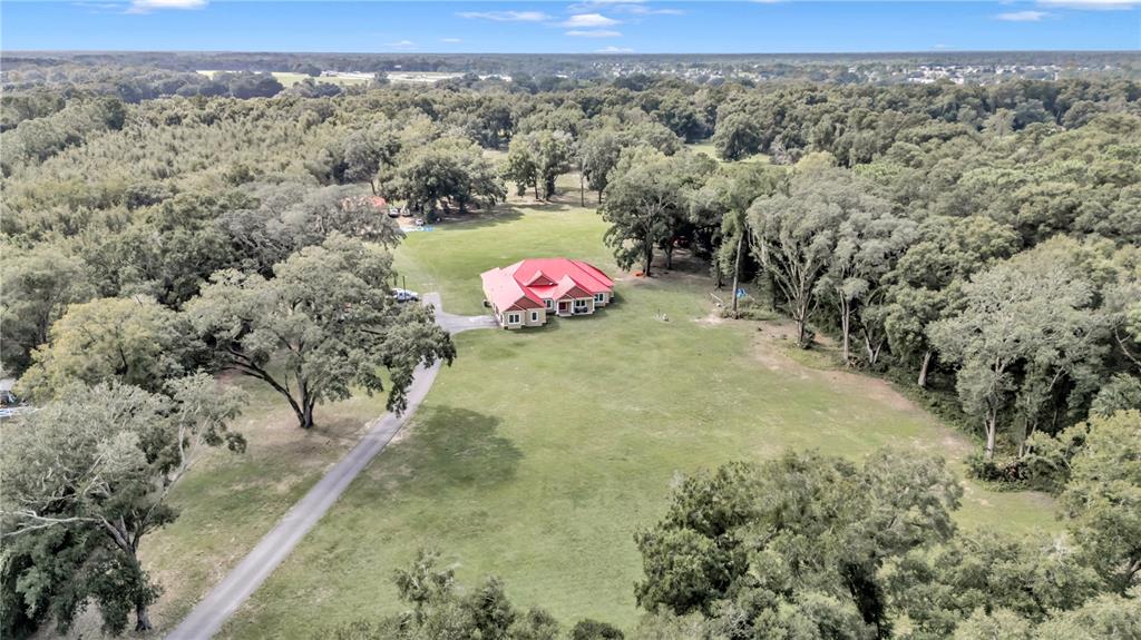 An aerial view shows a house with a red roof situated on a large lot — 14742 SW 4TH AVENUE, OCALA, FL