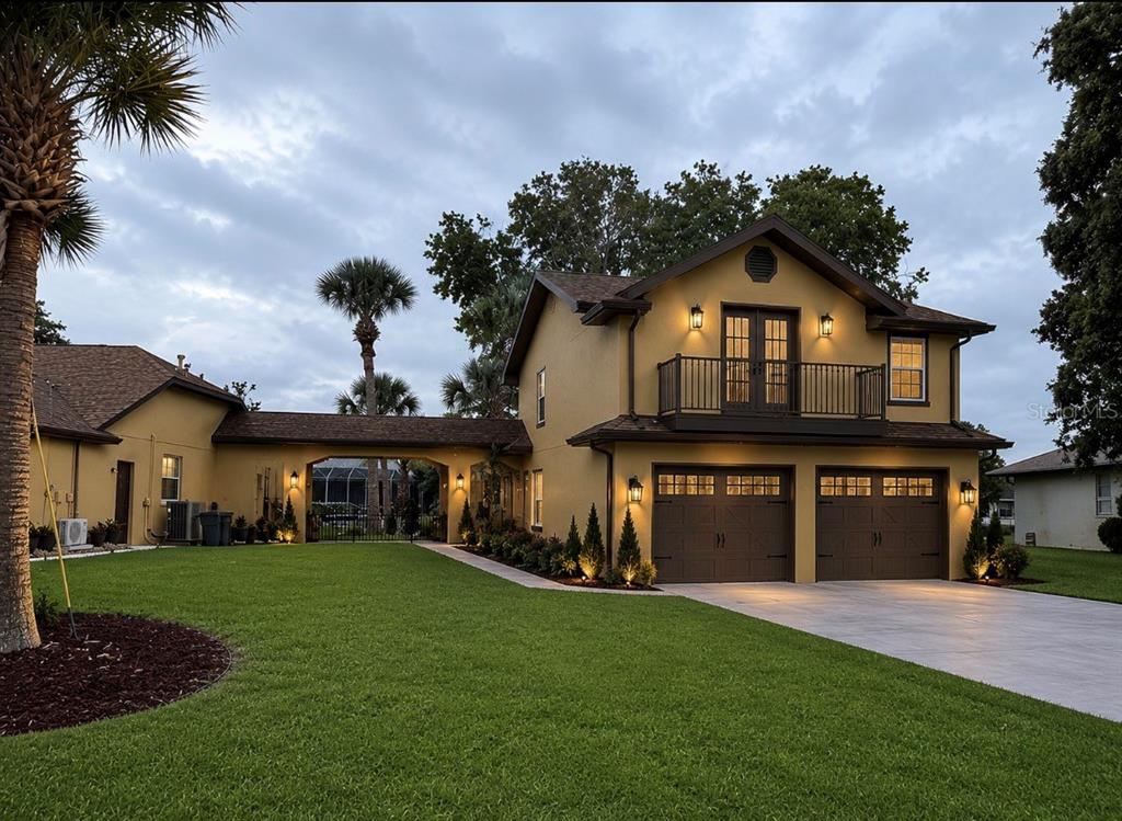 A two-story yellow house with a two-car garage, balcony, and a covered walkway — 25 COTTONWOOD COURT, PALM COAST, FL