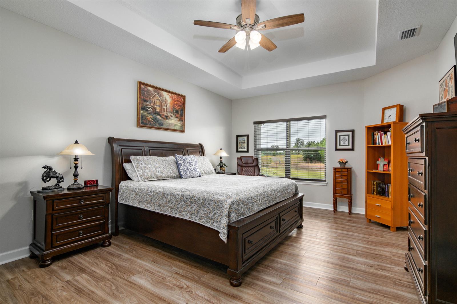 A bedroom features a wooden bed frame, ceiling fan, and light wood-look flooring — 10172 98th Path # 2, FL 32060, FL