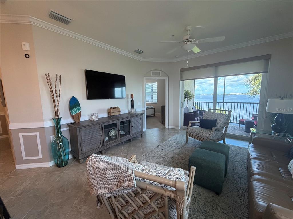A vibrant sunset over a calm body of water with dark vegetation in the foreground — 920 TIDEWATER SHORES LOOP UNIT 308, BRADENTON, FL
