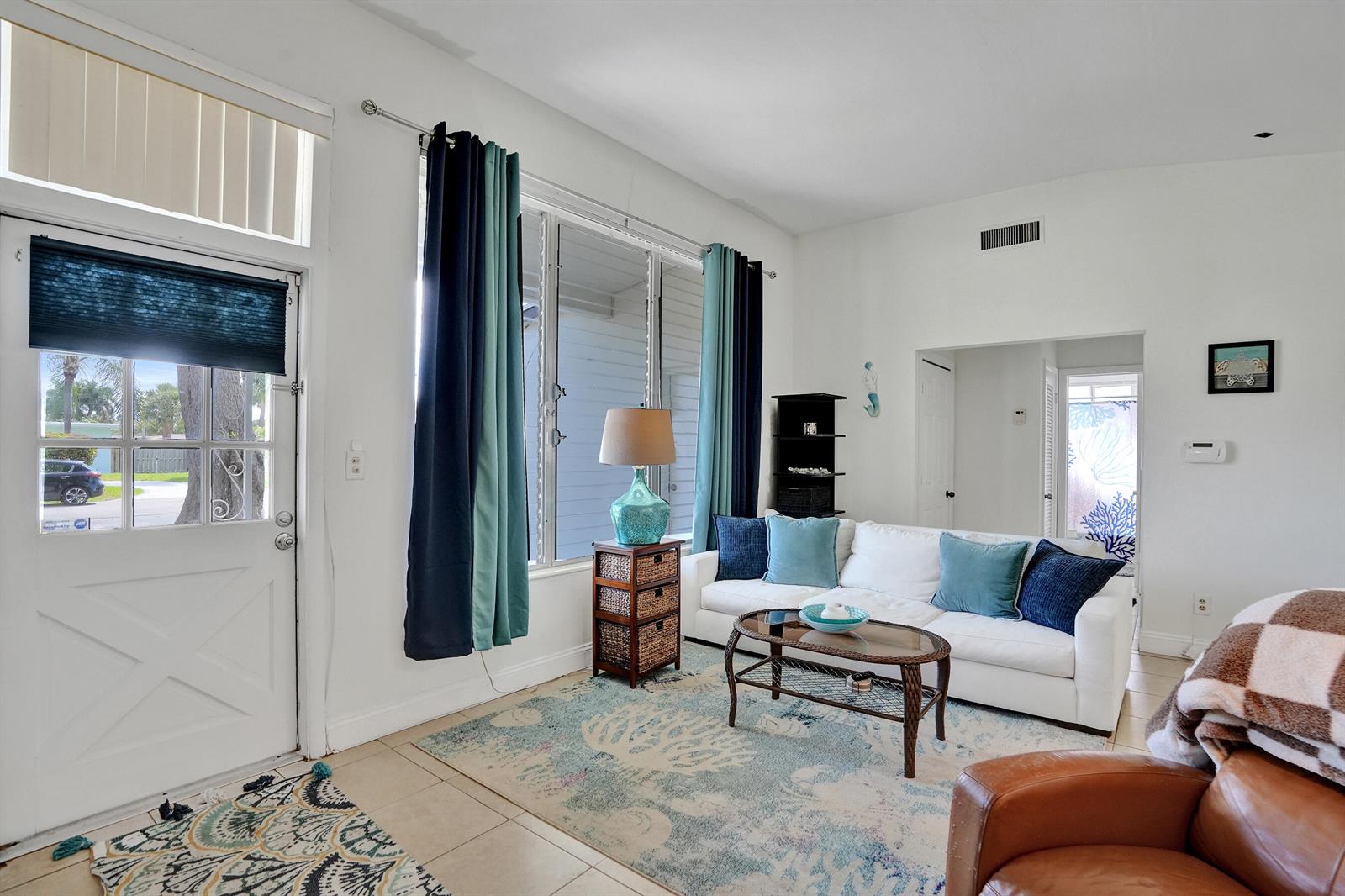 A living room features a white sofa, a coffee table, and a blue area rug — 2461 NE 20th Avenue, Lighthouse Point FL 33064, LIGHTHOUSE POINT, FL