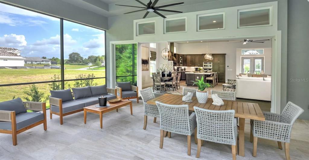 A modern kitchen features wood cabinets, a large white island, and stainless steel appliances — 177 ASPEN WAY, PALM COAST, FL