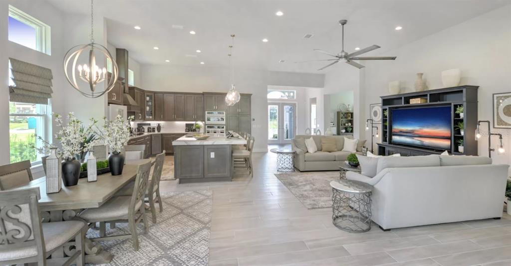 A modern kitchen features wood cabinets, stainless steel appliances, a large island, and tile flooring — 177 ASPEN WAY, PALM COAST, FL