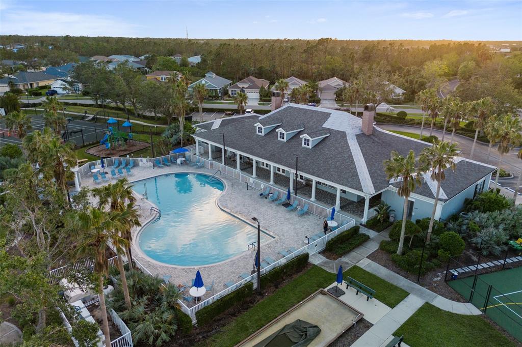 An aerial view shows a community clubhouse with a pool, playground, and tennis courts — 1183 JONAH DRIVE, NORTH PORT, FL