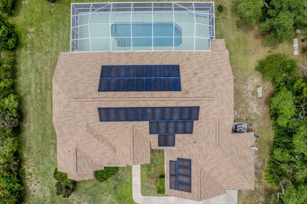 An aerial view of a house with a screened pool and solar panels on the roof — 20811 SW 81ST LOOP, DUNNELLON, FL