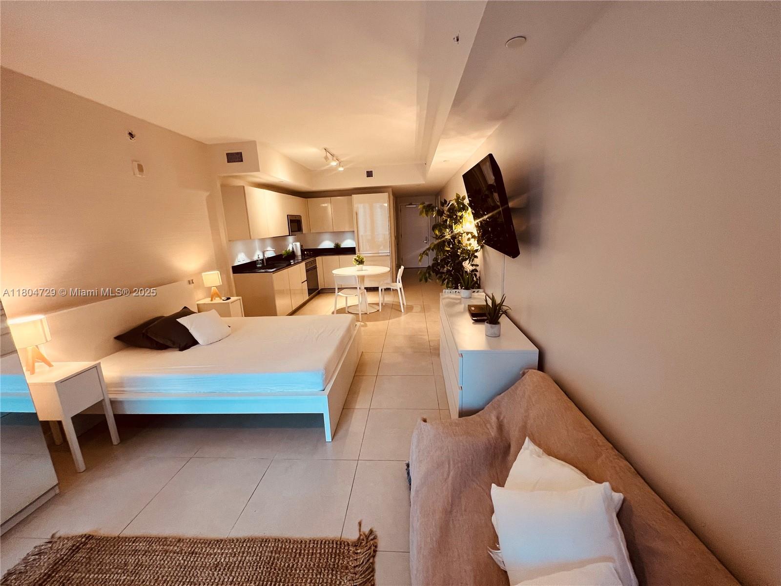 This studio apartment features a bed, a small kitchen, and a living area with tile floors — 1010 Brickell Ave # 2710, Miami FL 33131, MIAMI, FL