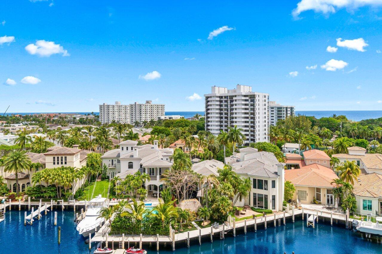 An aerial view of waterfront luxury homes with private docks and boats along a canal — 4740 S Ocean Boulevard # 903, Highland Beach FL 33487, HIGHLAND BEACH, FL
