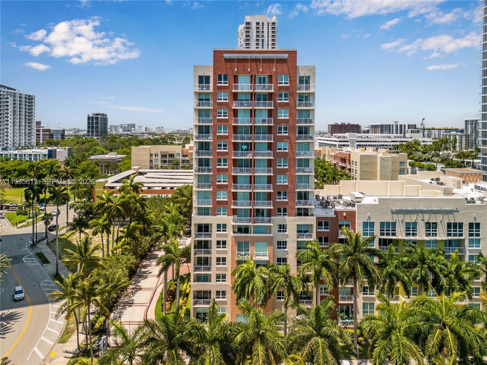 An aerial view shows a tall, multi-story residential building surrounded by palm trees and roads — 2000 N Bayshore Dr # 702, Miami FL 33137, MIAMI, FL