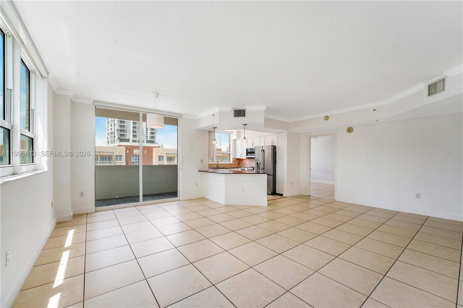 An open-concept living area features tile flooring, a kitchen with a breakfast bar, and balcony access — 2000 N Bayshore Dr # 702, Miami FL 33137, MIAMI, FL