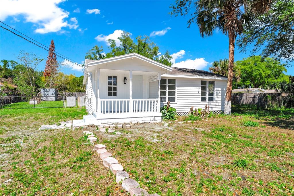 A small, white, single-story house with a front porch sits on a grassy lot — 4311 TONY STREET, ORLANDO, FL