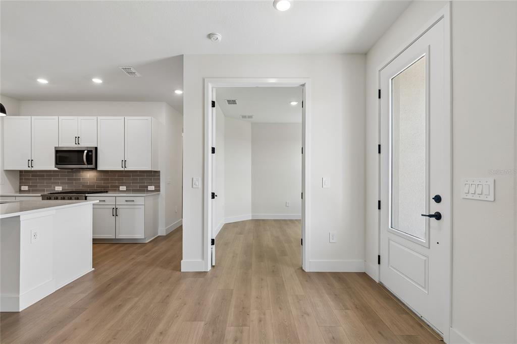 A view of a kitchen with white cabinets and a doorway leading to another room — 2808 MARRAKESH LANE, SARASOTA, FL