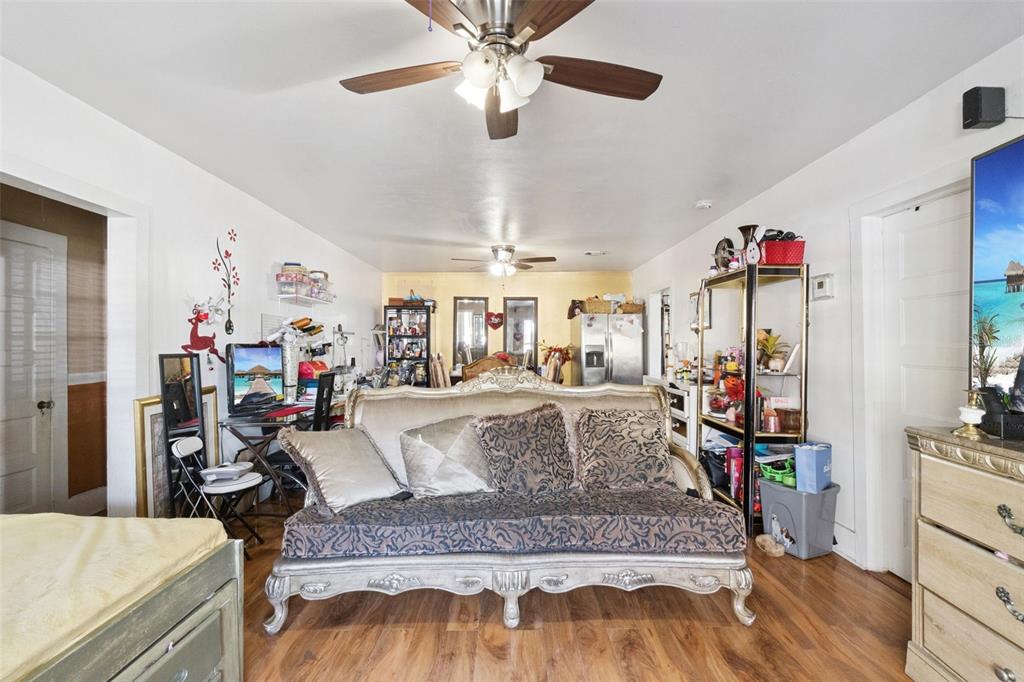 A living room features a patterned sofa, a ceiling fan, and a computer desk area — 310 E MAGNOLIA STREET, KISSIMMEE, FL